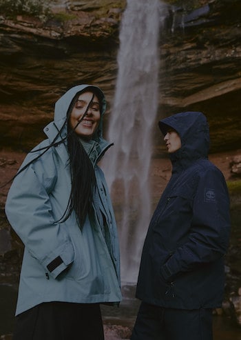 Woman and man standing on a rock wearing Timberland Boots and Apparel.